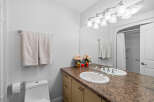 This bright and clean bathroom features a spacious vanity with a double sink and ample counter space, perfect for morning routines.