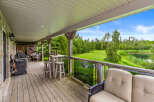 Enjoy outdoor living on this spacious covered deck, complete with a grill for entertaining and a charming bar area with stools.