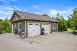 Discover this charming property featuring a spacious garage with two white doors, perfect for vehicle storage or a workshop.