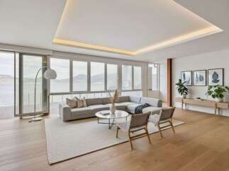 Experience breathtaking ocean views from this modern living room, featuring a spacious sectional sofa and a minimalist coffee table.