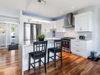 Experience modern living in this stunning kitchen, featuring sleek white cabinetry, a durable granite countertop, and a full suite of stainless steel appliances.