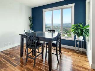 Experience breathtaking views from this elegant dining area, featuring a dark wood table and chairs set against a striking navy blue accent wall.