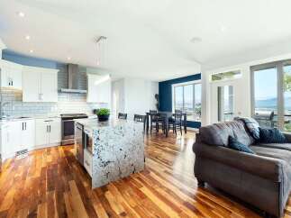 Experience modern living in this open-concept home featuring a gourmet kitchen with a granite island and sleek white cabinetry.
