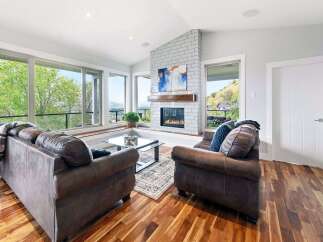 Experience breathtaking views from this stunning living room, featuring a modern fireplace and expansive windows that flood the space with natural light.