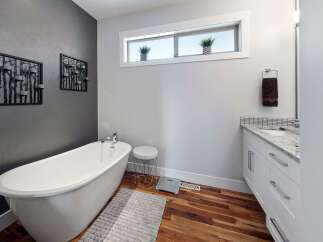 Experience tranquility in this modern bathroom, featuring a luxurious freestanding bathtub perfect for unwinding.