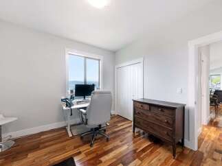 This home office features a sleek white desk with a computer and office chair, perfect for remote work.