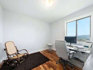 This home office features a comfortable rocking chair and a modern desk setup with a computer, perfect for productive workdays.