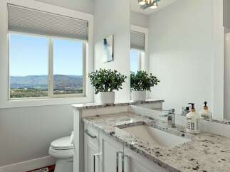 Experience breathtaking views from this stunning bathroom, featuring a large window overlooking rolling hills and a serene landscape.