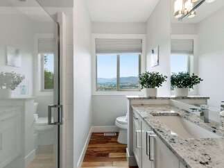 Experience modern comfort in this beautifully appointed bathroom, featuring a sleek glass shower and a spacious vanity with a granite countertop.