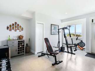 Transform this versatile space into your personal home gym, complete with a weight machine, adjustable bench, and rowing machine.