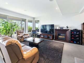 Experience ultimate relaxation in this inviting living room, featuring plush leather recliners and a spacious sofa perfect for family gatherings.