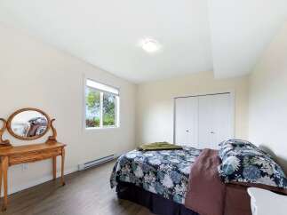 This charming bedroom features a comfortable queen-size bed with a floral comforter and a cozy green throw.