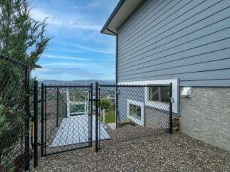 Enjoy stunning panoramic views from this property, featuring a secure chain-link fence enclosing a spacious outdoor area.