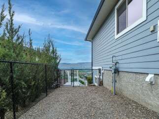 Enjoy breathtaking views from this property, featuring a secure chain-link fence surrounding lush greenery.
