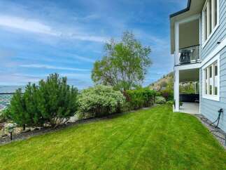 Enjoy breathtaking views from this stunning property, featuring a beautifully manicured lawn and lush landscaping.