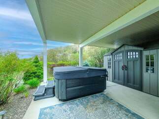 Enjoy ultimate relaxation in this backyard oasis, featuring a covered patio with a luxurious hot tub perfect for unwinding.