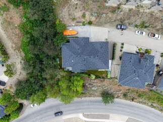 Discover this stunning aerial view of a modern home nestled in a serene, natural landscape.