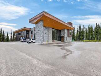 Discover this stunning modern commercial building nestled amidst a serene forest landscape.