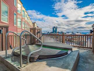 Enjoy breathtaking mountain views from this luxurious rooftop hot tub, perfect for unwinding after a day on the slopes.