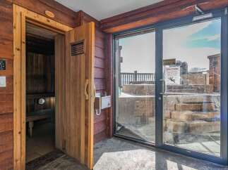 Experience ultimate relaxation in this luxurious sauna, featuring rich wood paneling and a modern control panel for personalized settings.