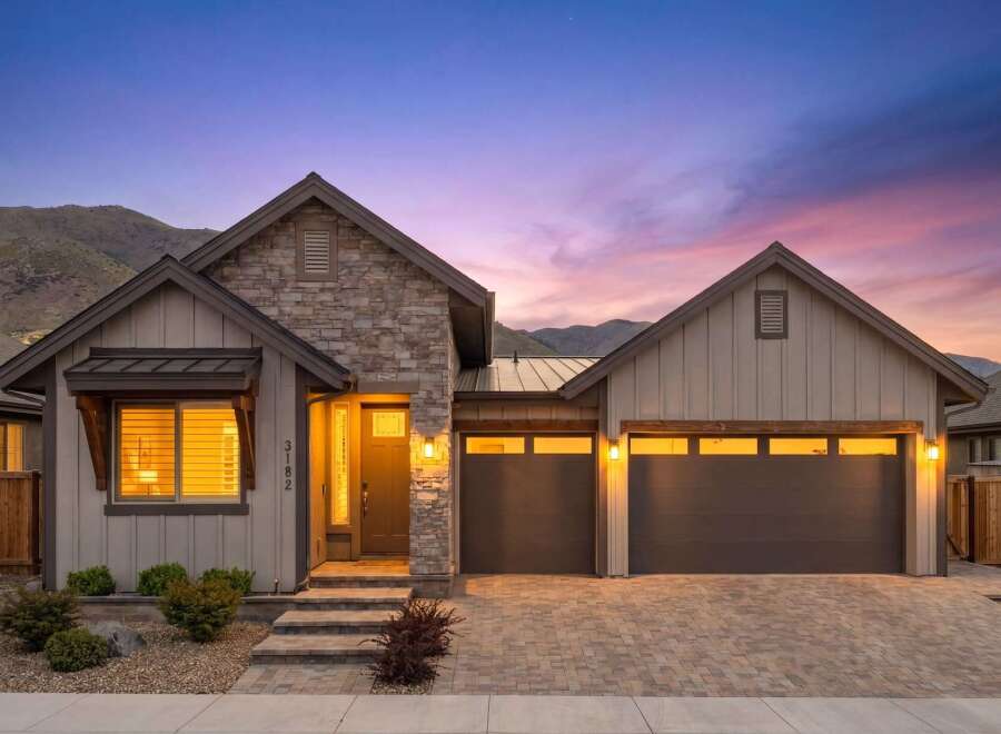 Experience luxury living in this stunning modern home, featuring a striking stone and wood exterior.
