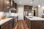 Experience luxury in this stunning modern kitchen, featuring sleek dark wood cabinetry and gleaming stainless steel appliances.