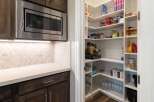 Discover ample storage with this spacious walk-in pantry, featuring custom shelving to organize all your culinary essentials.