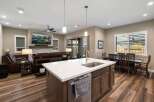 This spacious open-concept living area features a modern kitchen island with a sink, perfect for entertaining.
