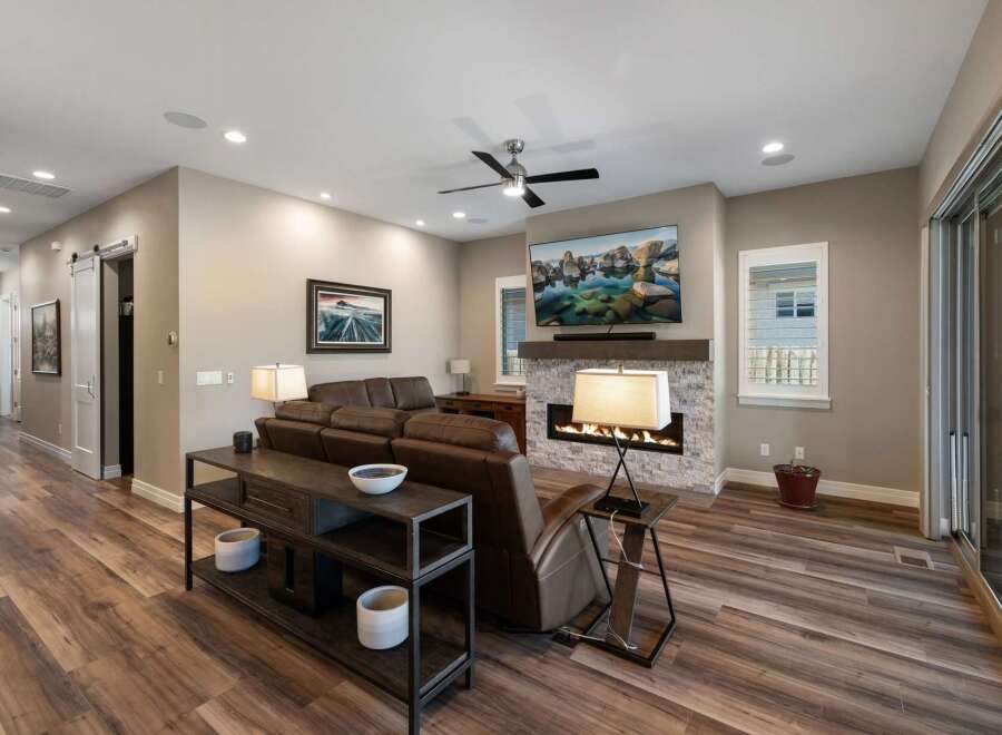 Experience modern living in this spacious living room, featuring a cozy fireplace and a large flat-screen TV perfect for entertainment.