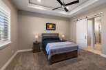 Experience luxurious comfort in this master bedroom, featuring a spacious king-size bed with elegant dark wood furniture and a cozy striped throw.