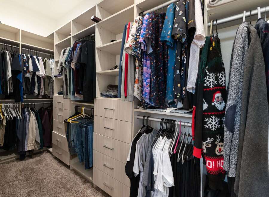 Discover ample storage in this spacious walk-in closet, featuring custom shelving and multiple drawers to keep your wardrobe organized.