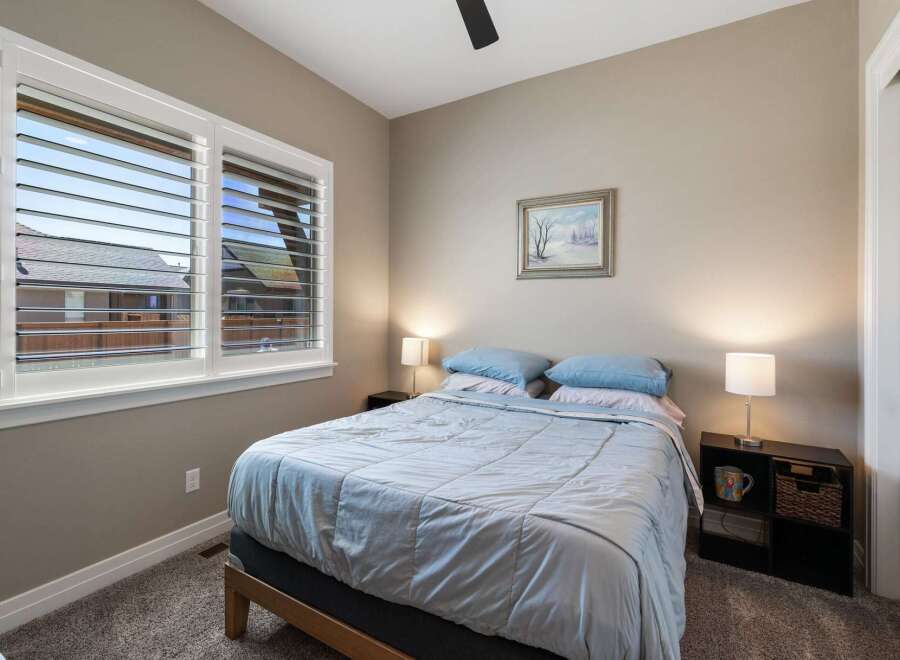 This cozy bedroom features a comfortable queen-size bed dressed in soft blue linens, perfect for a restful night's sleep.