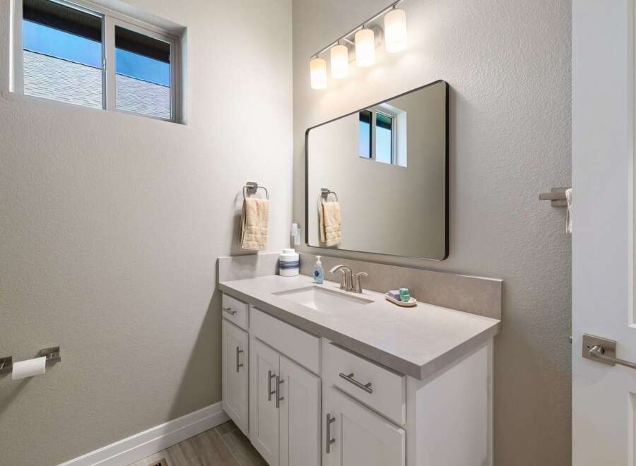 This modern bathroom features a sleek vanity with ample storage and a quartz countertop.