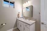 This modern bathroom features a sleek vanity with ample storage and a quartz countertop.