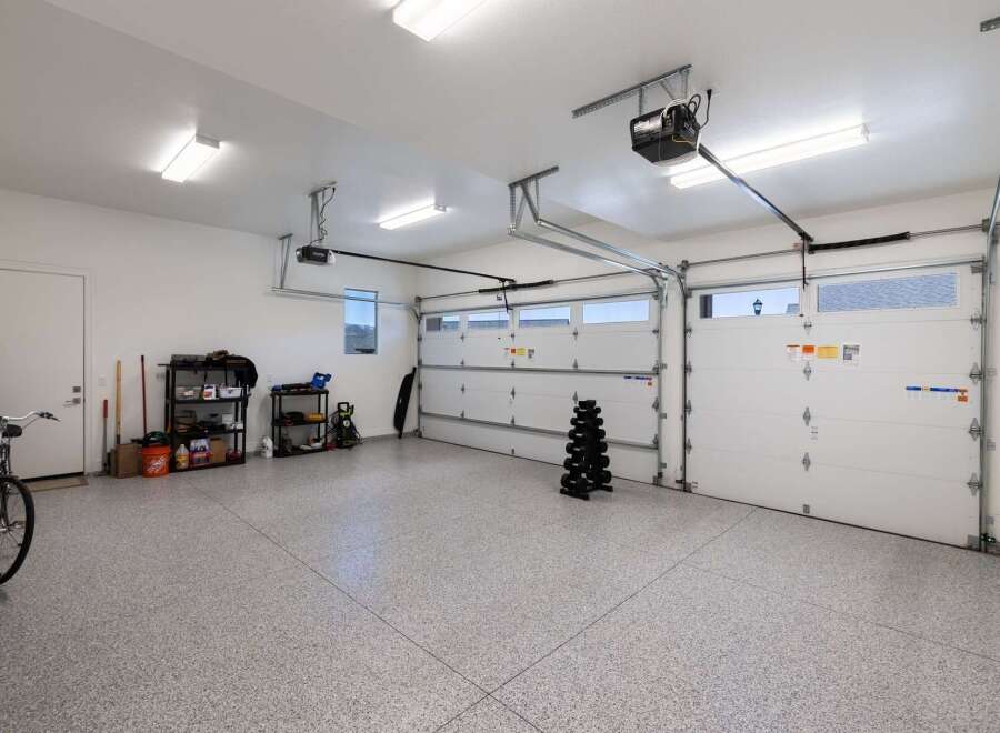This spacious garage offers ample storage with multiple shelving units and a dedicated area for a bicycle.
