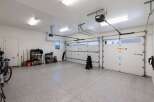 This spacious garage offers ample storage with multiple shelving units and a dedicated area for a bicycle.