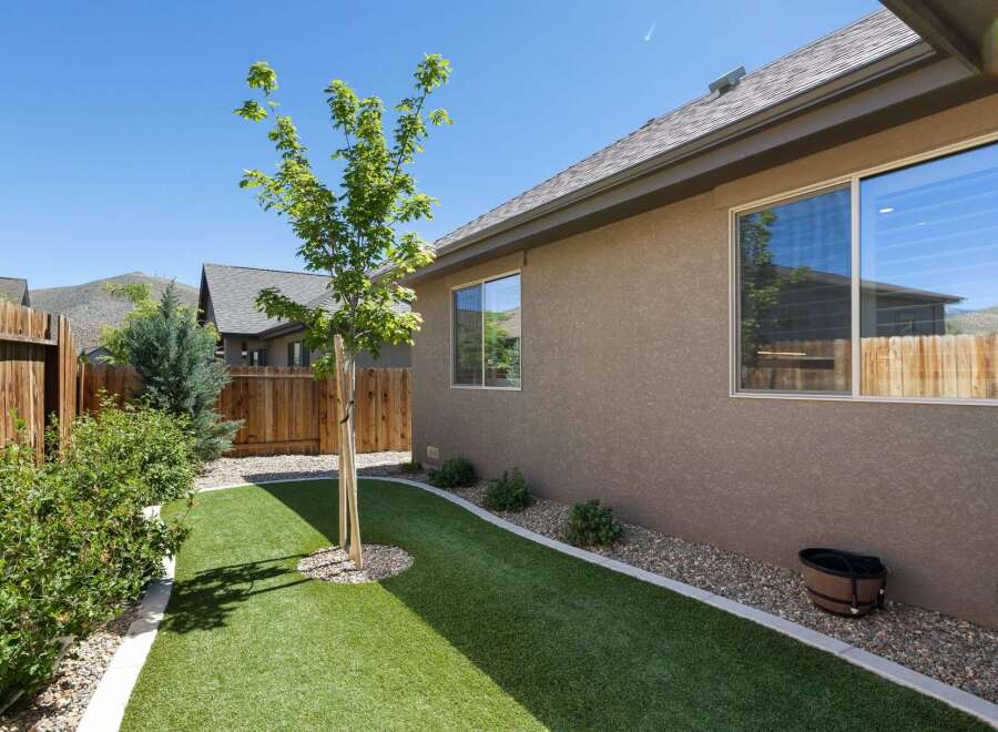 Discover this charming backyard oasis featuring a lush, low-maintenance artificial turf lawn perfect for relaxation and play.