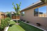 Discover this charming backyard oasis featuring a lush, low-maintenance artificial turf lawn perfect for relaxation and play.