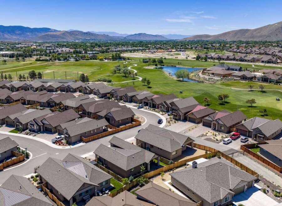 Discover modern living in this stunning aerial view of a suburban neighborhood adjacent to a lush golf course.