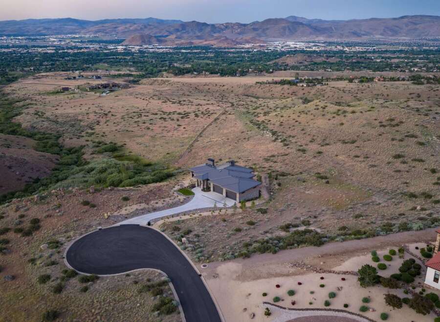 Experience luxury living in this stunning modern home, nestled in a serene, elevated landscape with panoramic views of the distant city and mountains.