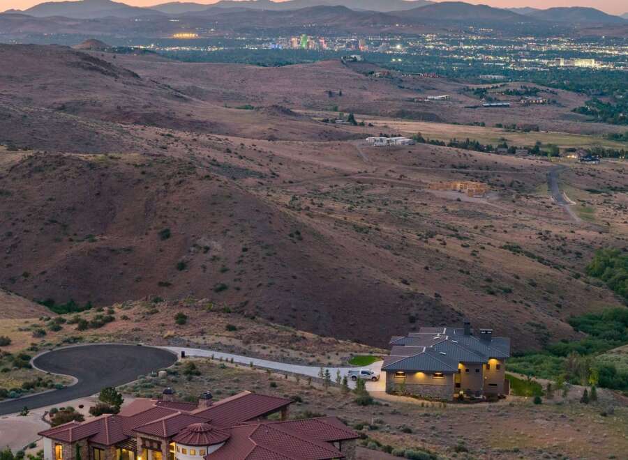 Experience luxury living with this stunning hillside estate offering panoramic views of the city lights.