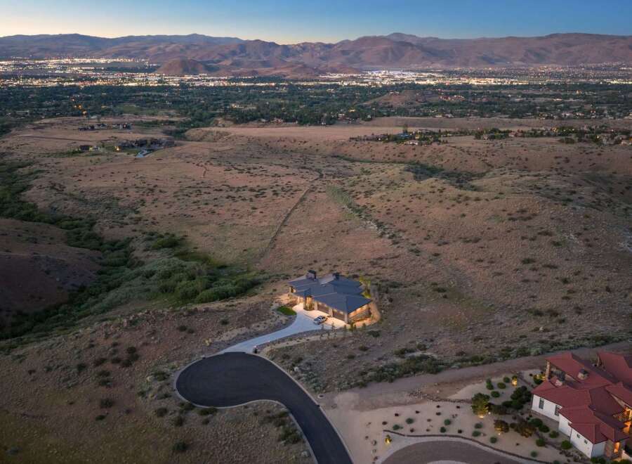 Experience luxury living with this stunning estate offering panoramic views of the city lights and surrounding mountains.