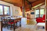 Experience cozy living in this charming mountain retreat, featuring a rustic wooden dining table with four chairs, perfect for family meals.