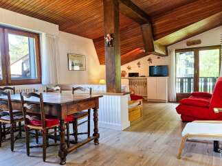 Experience cozy living in this charming mountain retreat, featuring a rustic wooden dining table with four chairs, perfect for family meals.