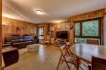 This cozy living room features warm wood-paneled walls and a comfortable leather sofa set, perfect for relaxation.