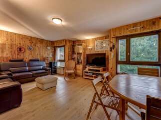 This cozy living room features warm wood-paneled walls and a comfortable leather sofa set, perfect for relaxation.