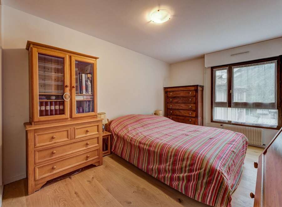 This charming bedroom features a cozy bed with a striped comforter, perfect for relaxation.