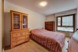 This charming bedroom features a cozy bed with a striped comforter, perfect for relaxation.