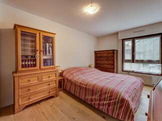 This charming bedroom features a cozy bed with a striped comforter, perfect for relaxation.