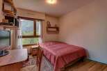This cozy bedroom offers a comfortable single bed with a striking red patterned duvet, perfect for a peaceful retreat.